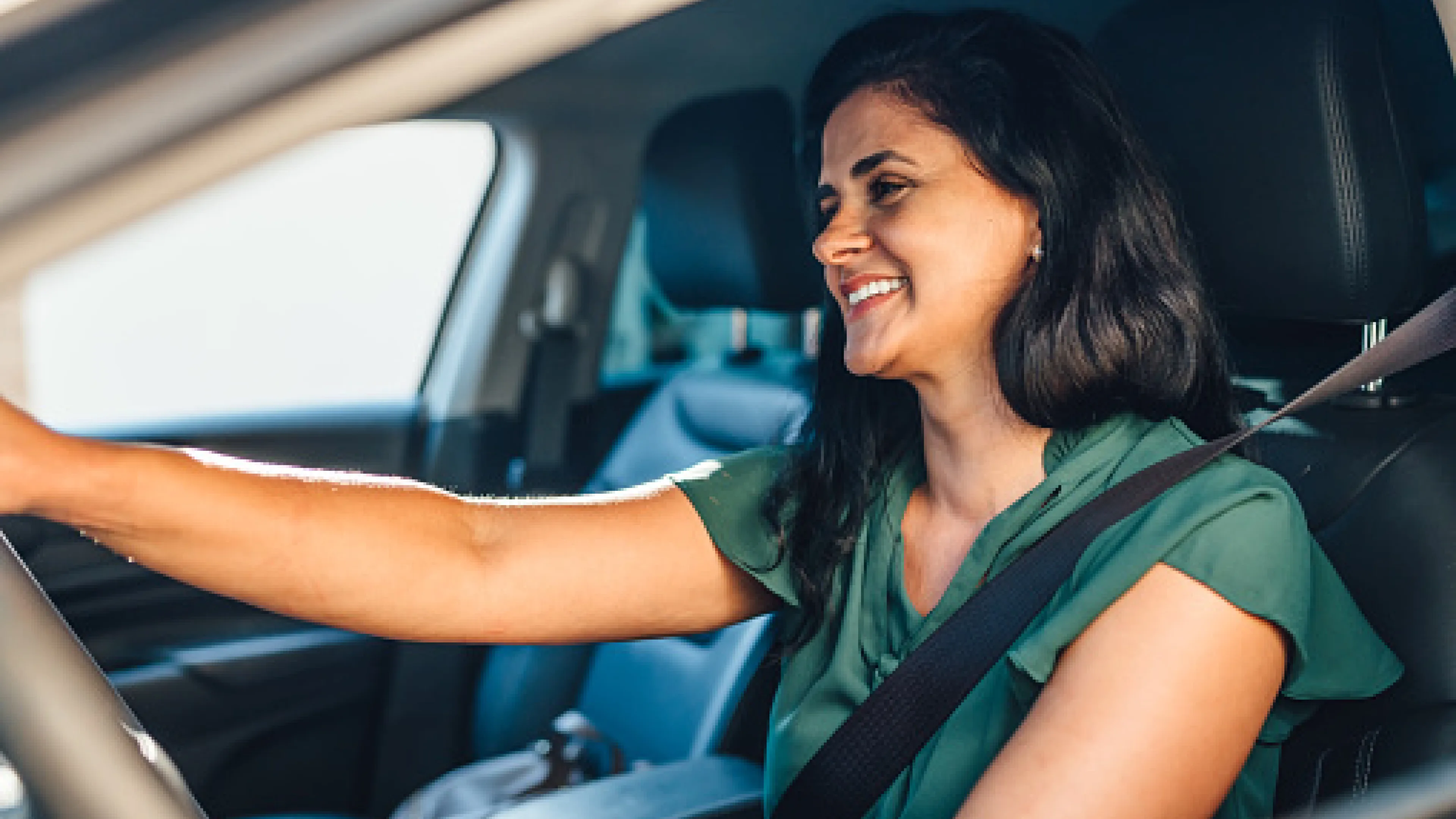 Woman driving car smiling